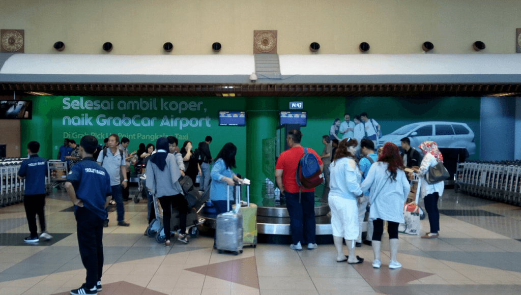 Iklan GrabCar Airport di ruang bagasi Bandara SMB II Palembang