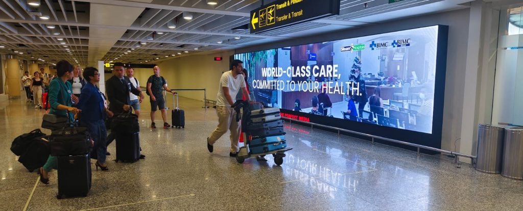 Iklan rumah sakit Siloam di layar LED Bandara Internasional I Gusti Ngurah Rai Bali menampilkan hospital internationally accredited untuk medical tourism.