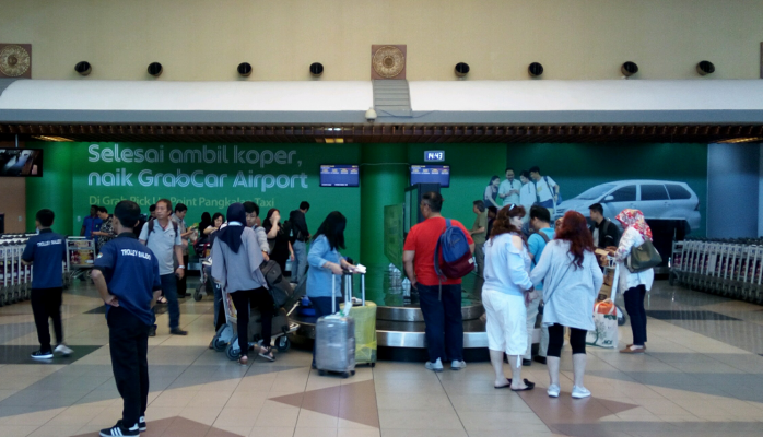 Iklan GrabCar Airport di ruang bagasi Bandara SMB II Palembang